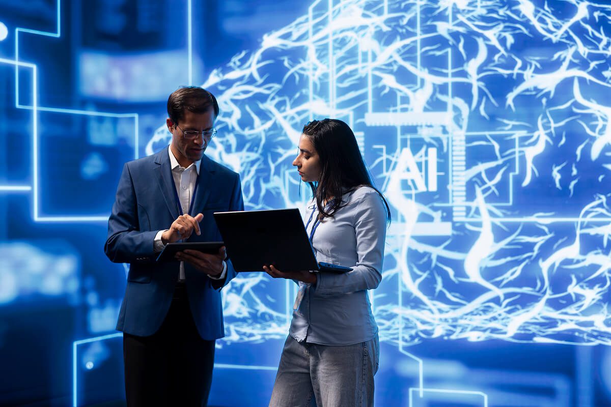 Two people discussing AI technology with laptops.